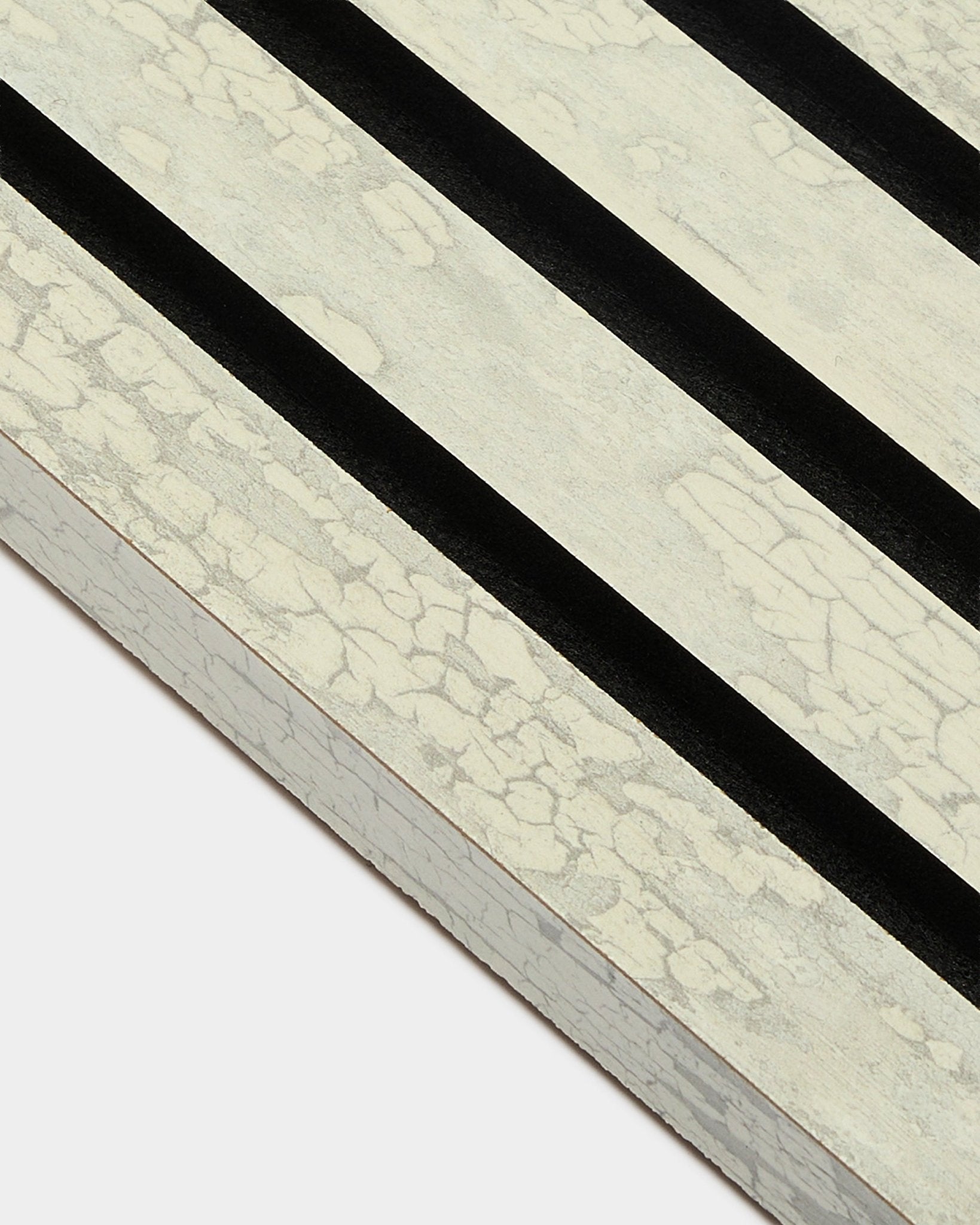 Close-up van WoodUpp Akupanel End Lamella in Oxide White (2,2 cm) met drie diagonale black strepen op een MDF Akoestisch paneel-frame.